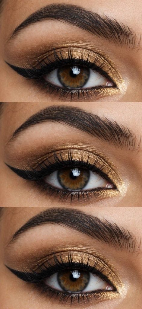 A close-up of a smoky golden eye with brown iris, highlighted with shimmer and defined with dark eyeliner